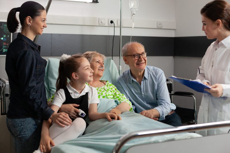 Physician doctor discussing sickness symptoms with retired elderly senior Physician doctor discussing sickness symptoms with retired elderly senior woman during clinical recovery, Caring cheerful family visiting sick retired patient in hospital ward supporting after surgery
